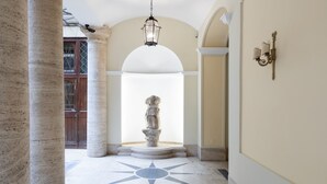 A hallway with a central statue, columns, and a star-patterned floor. - Elegant Salandra Suite (Rome)