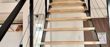 A modern staircase with wooden steps and black metal railings.