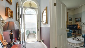 A room with a view to the sea, a fireplace, and a blue sofa. - Edwardian Beach Villa in Whitehead, Beach Front Period Edwardian Villa (Whitehead)
