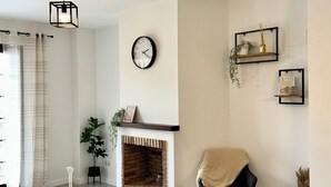 A modern living room with a fireplace, a clock, and a minimalist decor. - Hancinda Sleeps 4 With Free Parking (Fuente Alamo de Murcia)