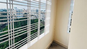 A corner room with a window overlooking a cityscape. -  Hotel Royal Palm (Sylhet)