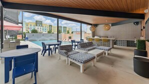 Eine Terrrasse im Freien mit Sitzgelegenheiten, einem Pool und Blick auf Gebäude im Hintergrund.