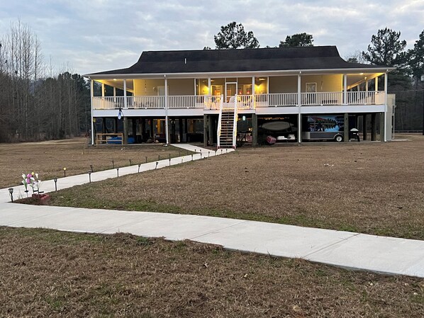 A two-story building with a covered porch, a garage, and a driveway.