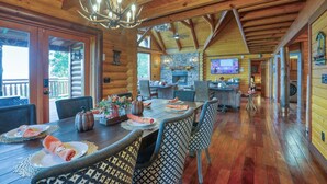 L’intérieur d’une cabane en rondins comprend un coin repas, une cuisine et une cheminée.
