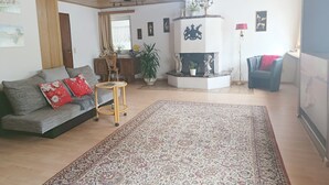 Un salon avec un canapé, une table basse, une cheminée et un tapis.