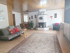 Ein Wohnzimmer mit einer Couch, einem Couchtisch, einem Kamin und einem Teppich.