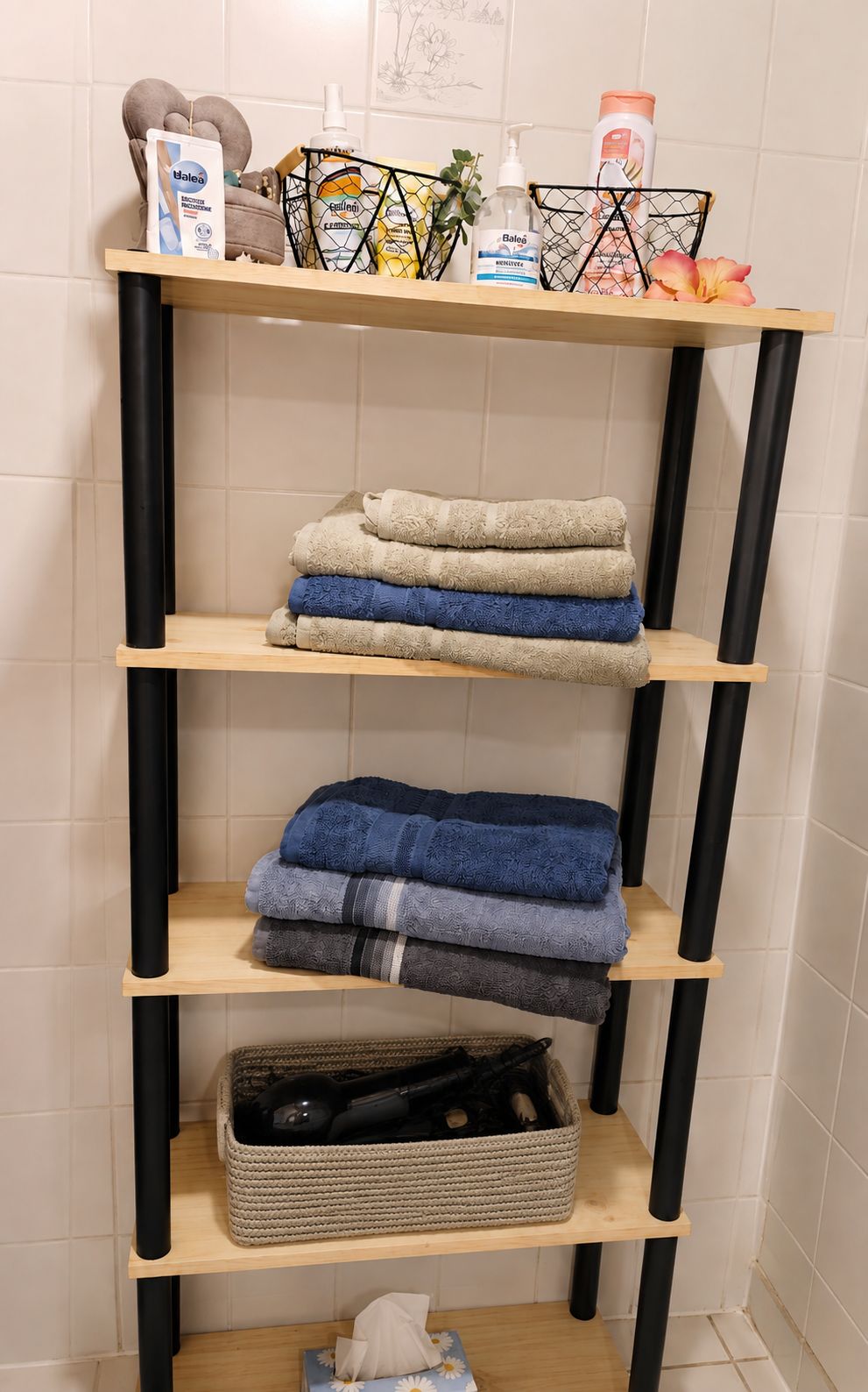 Ein Badezimmerschrank mit gefalteten Handtüchern, Pflegeprodukten und einem gewebten Korb.