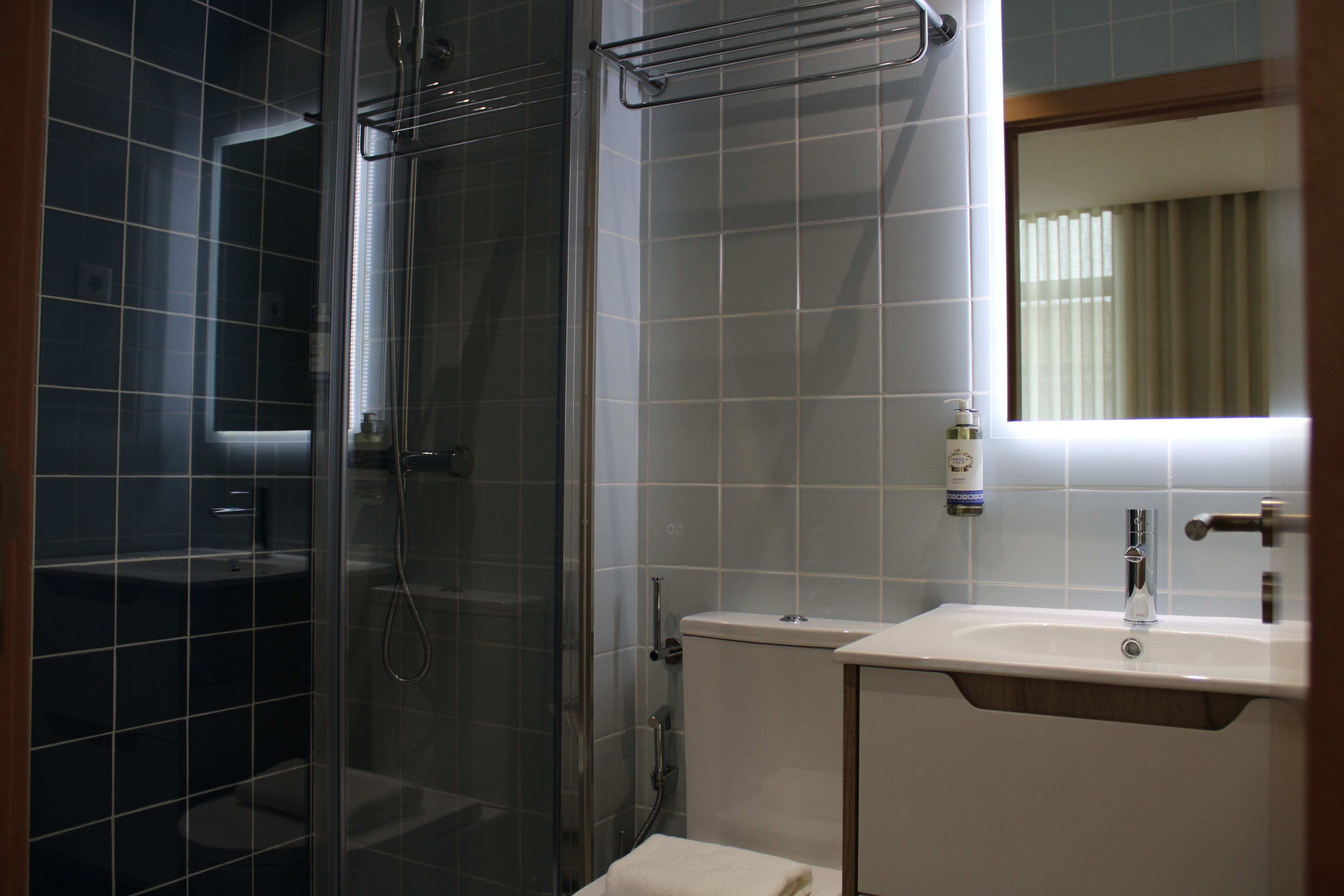 A bathroom with a glass-enclosed shower, a white sink, and a mirror above the sink.