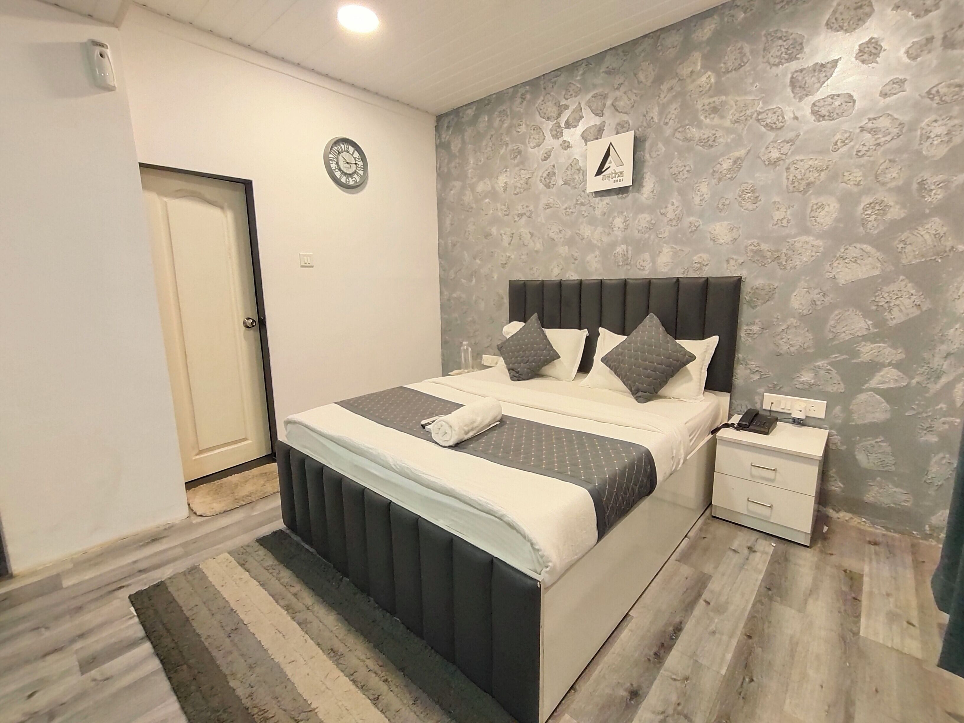 Ein Schlafzimmer mit einem Bett, einem Nachttisch und einer Wanduhr.