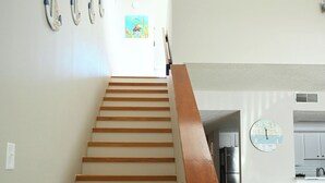A staircase with wooden steps leading to a kitchen area.