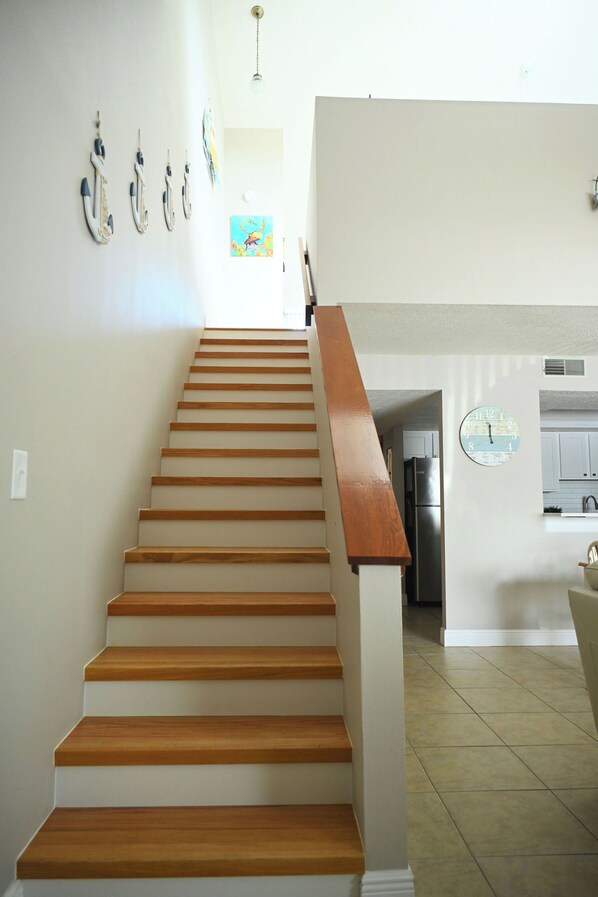 A staircase with wooden steps leading to a kitchen area.