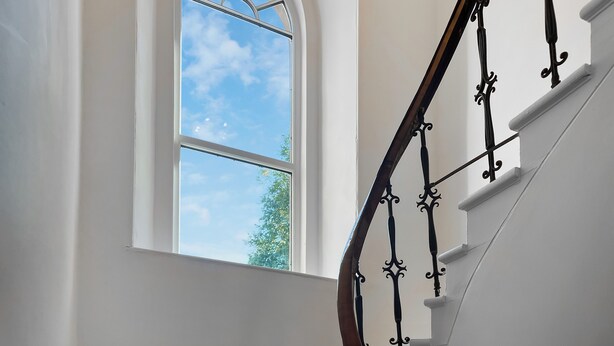 A staircase with a wrought iron railing and a white wall. - West Nevay Farm House (Newtyle, near Blairgowrie)