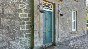 A stone building with a green door, a small window, and a doorbell. - West Nevay Farm House (Newtyle, near Blairgowrie)