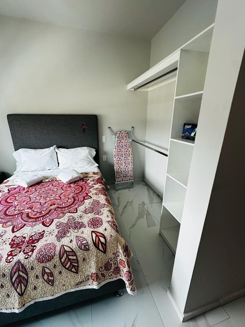 Une chambre à coucher avec un lit, une armoire et une couvre-lit à motifs.