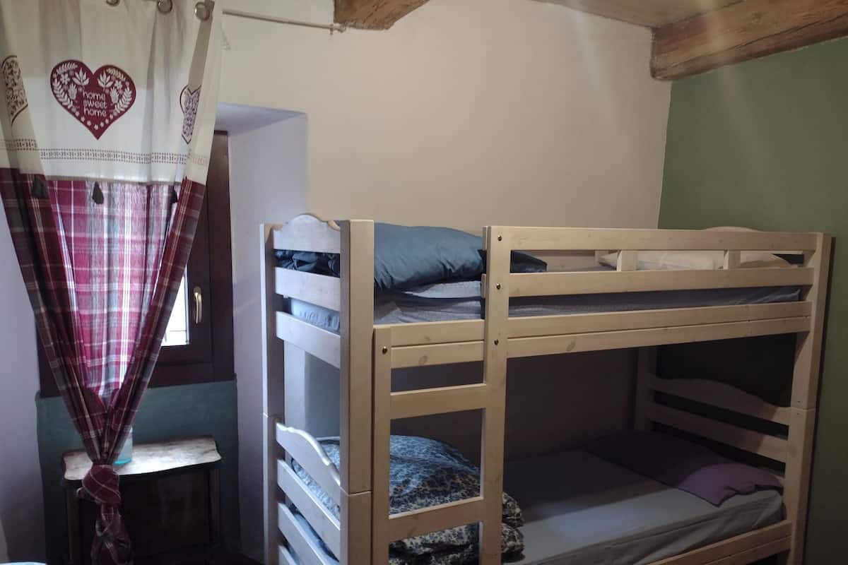 A bunk bed with a window and a curtain with a heart design.