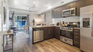Una cocina moderna con electrodomésticos de acero inoxidable, suelo de madera y una zona de comedor con vistas.