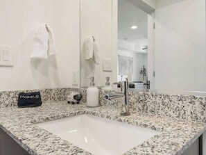 A bathroom with a granite countertop, a sink, a mirror, and a towel rack. - Cozy pet-friendly apt w/workspace & fire pit (Salt Lake City)