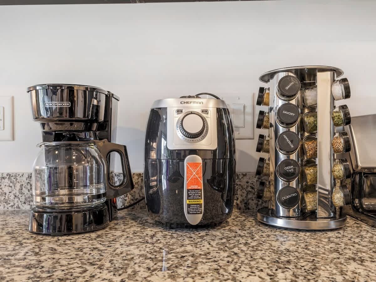 Kolme kahvinkeitintä keittiön työtasolla.