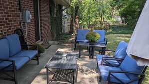 An outdoor patio area with a brick wall, a metal fence, and a potted plant. - UM Football - 5 blocks to Stadium (Ann Arbor)