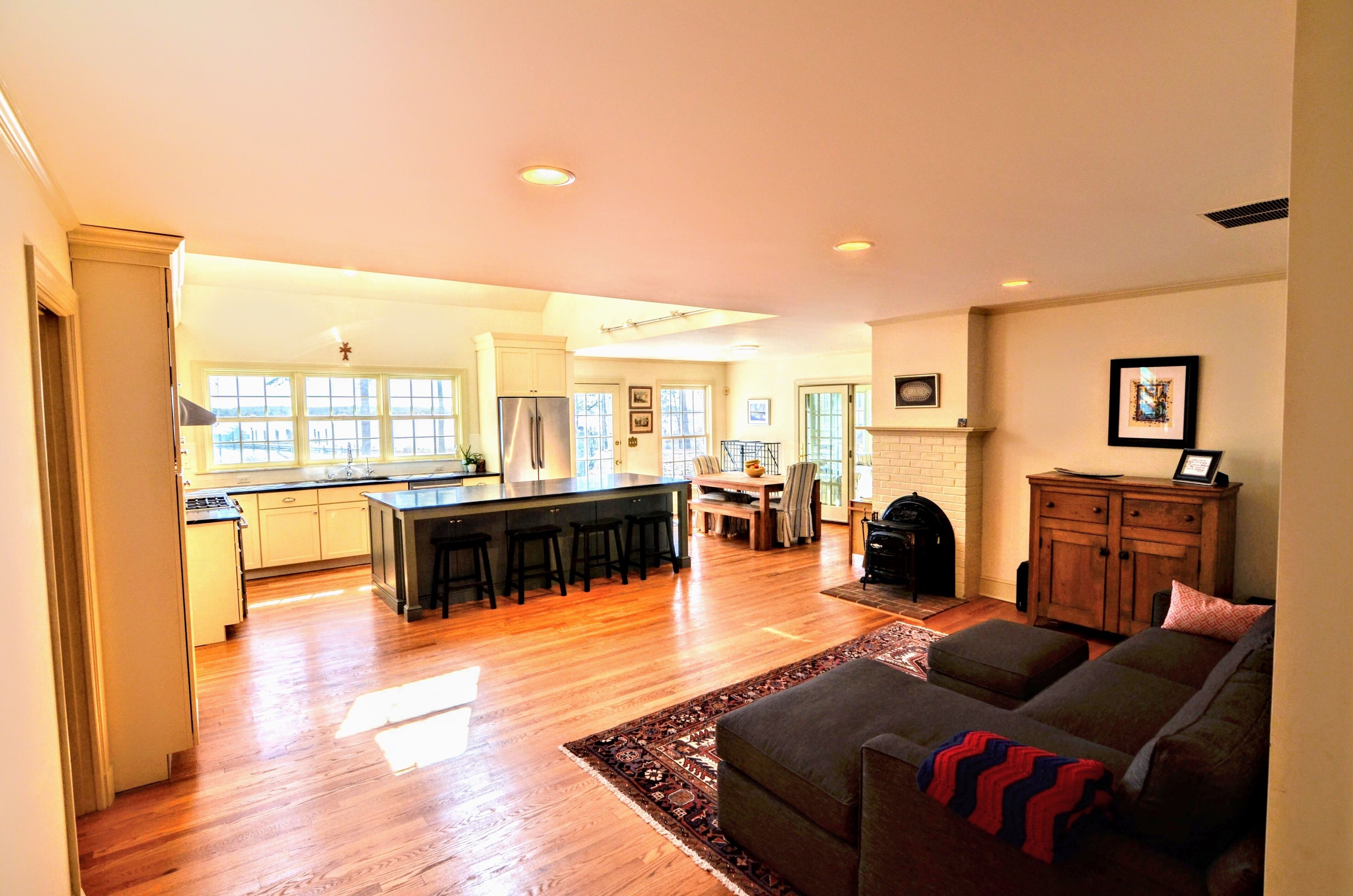 A spacious living area with a kitchen, a dining table, and a fireplace.