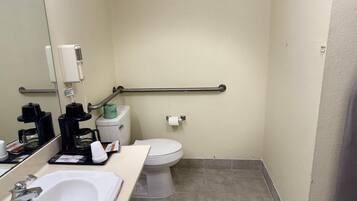 Une petite salle de bain compacte avec un lavabo blanc, des toilettes et un miroir.