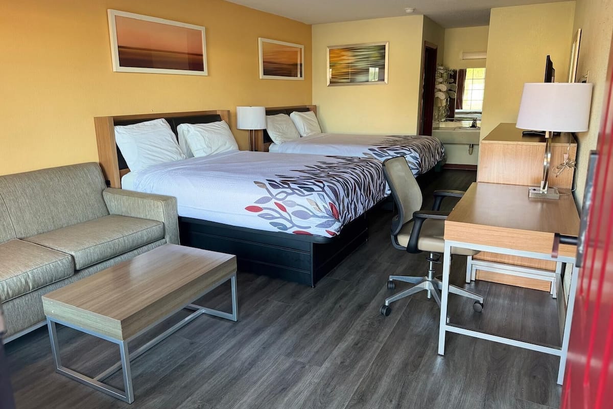 Una habitación de hotel con una cama grande, un sofá, un escritorio y una silla.
