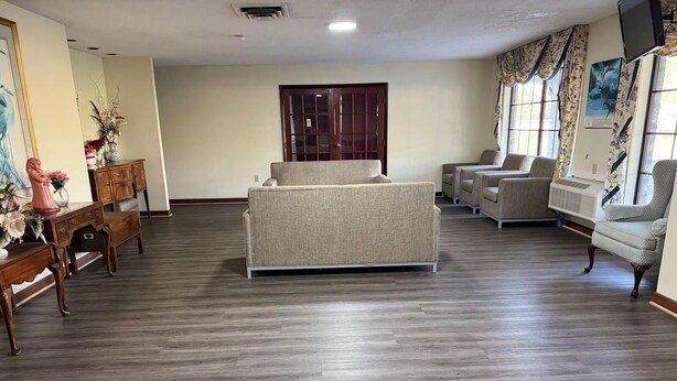 Un salón amplio con un sofá grande, varios sillones y una mesa de centro de madera.