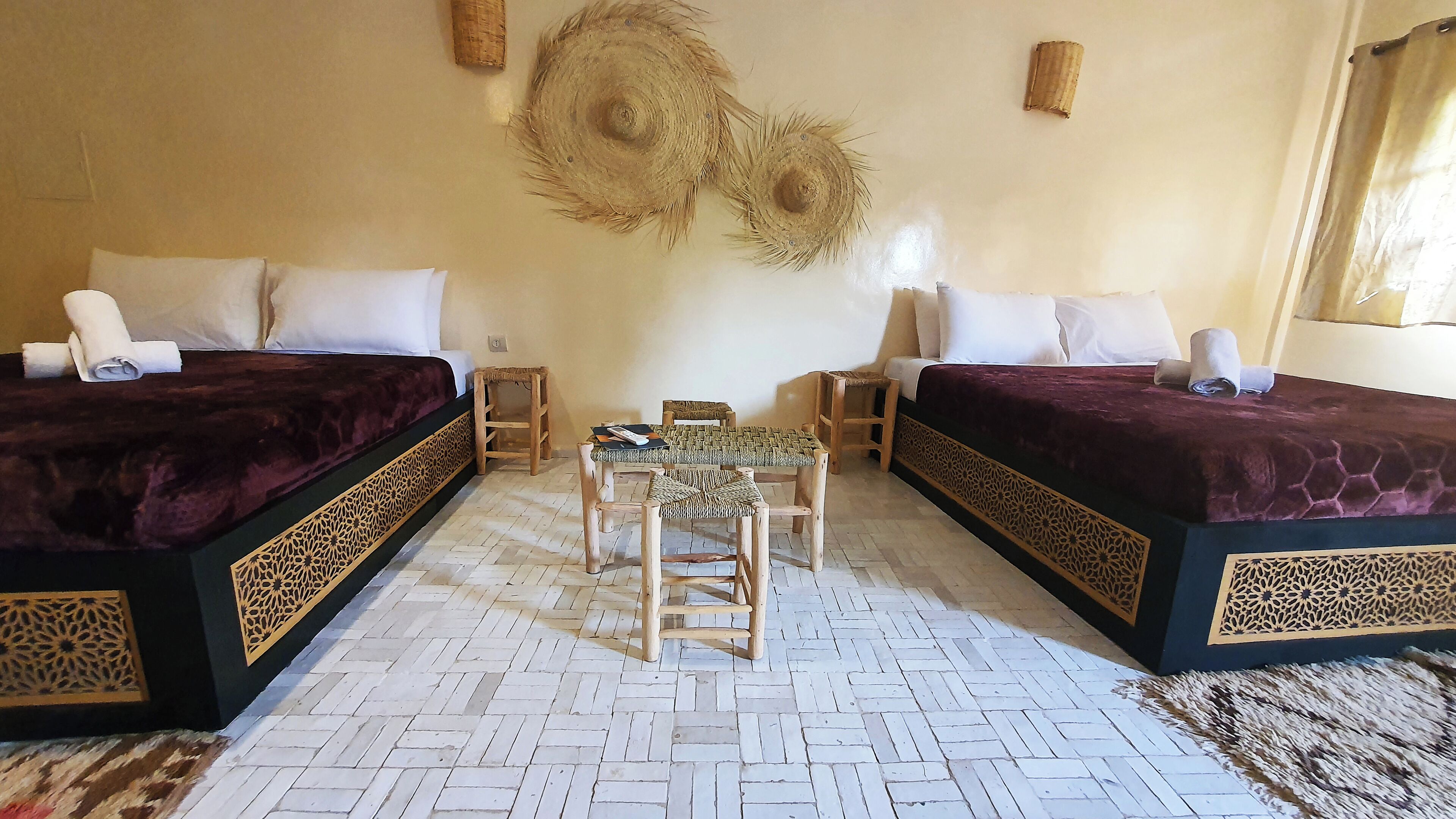 Une chambre d’hôtel avec deux lits, une petite table et des chaises.