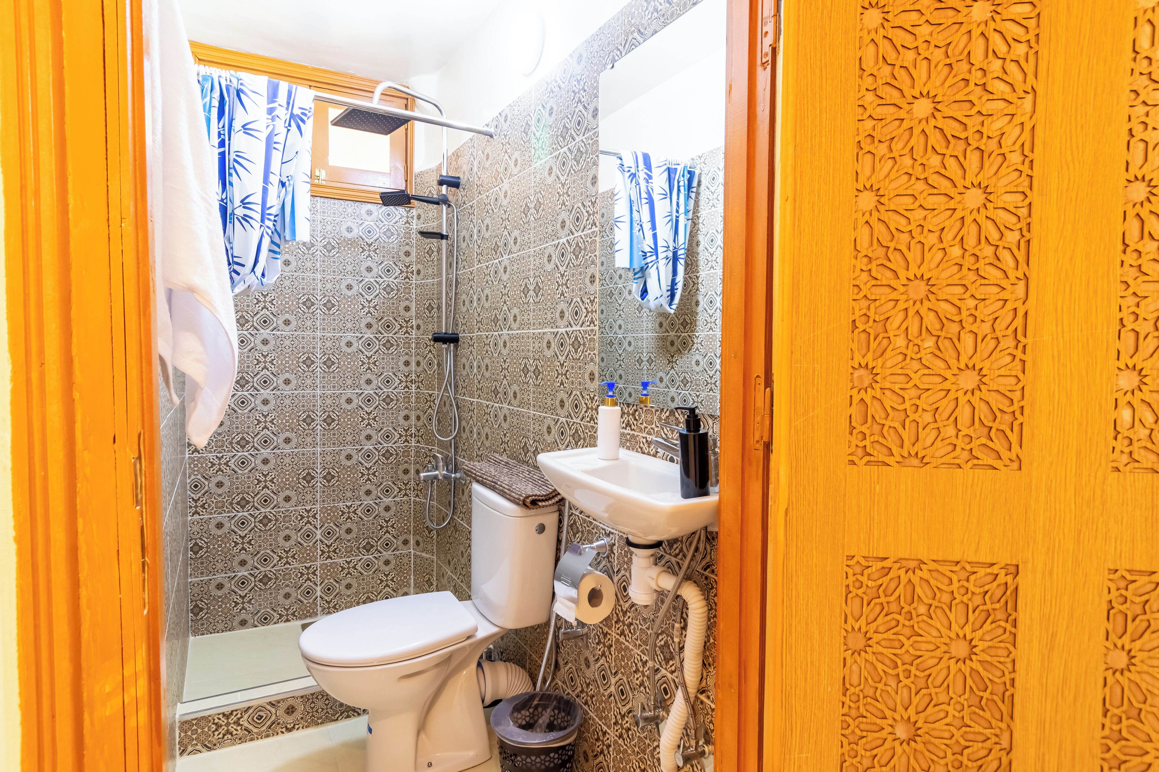 A bathroom with a toilet, shower, and sink.