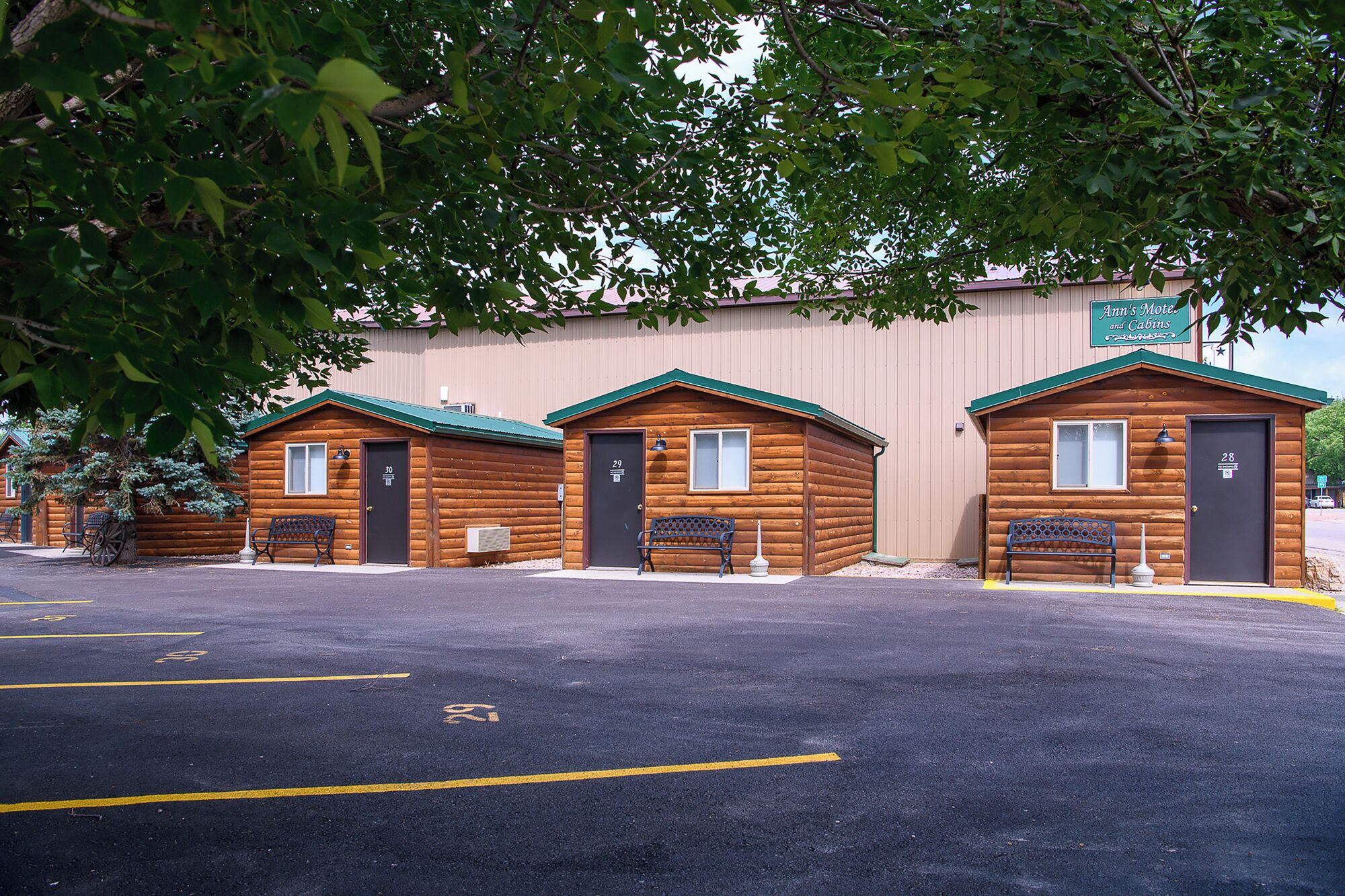 A row of log cabins with a sign above them reading "Ann's Motel and Cabins."