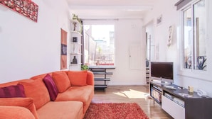 A modern living room with a sofa, TV, and bookshelf. - TERRACE DUPLEX at SAGRADA FAMILIA/GRACIA (Barcelona)