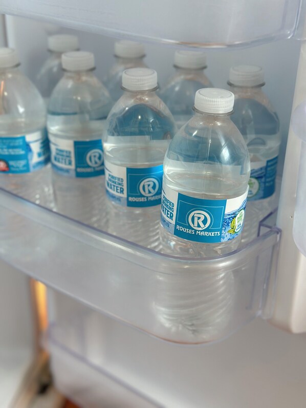 A refrigerator containing several bottles of water from Rouses Markets. - Chic Country Studio 8 miles from Lafayette (Rayne)