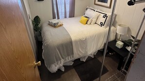 Una camera d'albergo spaziosa con un letto, un comodino, una lampada e una finestra con tende.