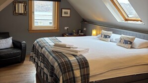 A bedroom with a large bed, a skylight, a ceiling fan, and a window. - Highland Rooms - Room Only No Breakfast (Ullapool)