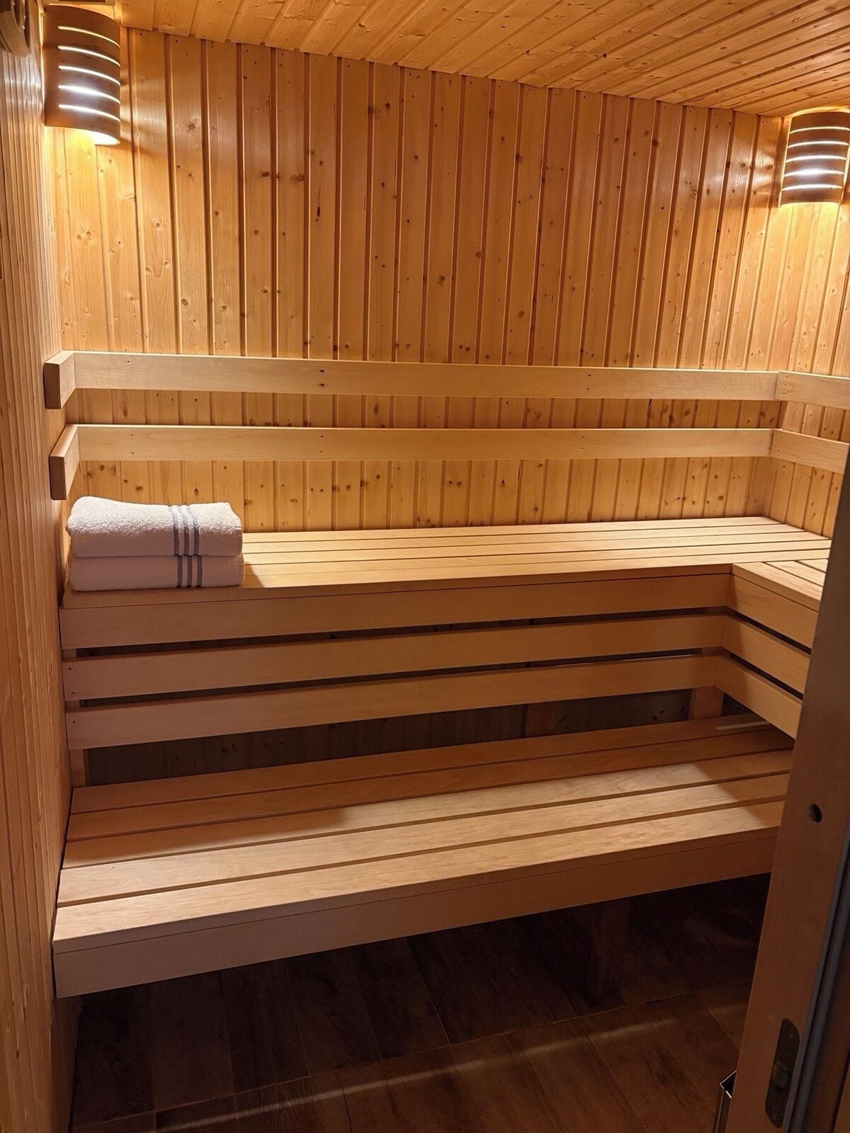 En träbeklädd bastu med sittbänkar och en handduk.