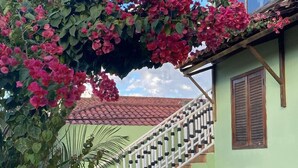 A staircase leading to a green-roofed building with a balcony. - Pousada Gama (Diamantina)