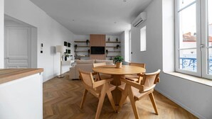 A modern kitchen with wooden cabinets, a built-in oven, and a large window. - Air-cond and designer apartment (Vichy)