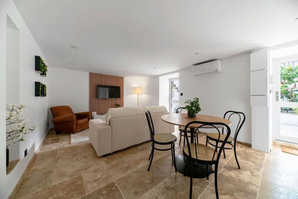 A modern living room with a sofa, armchair, dining table, and chairs. - Air-cond and designer apartment with terrace (Vichy)