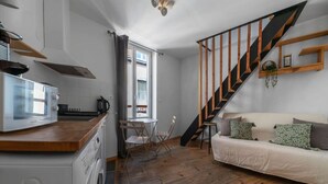 Un espacio habitable pequeño con cocina, comedor y una escalera.