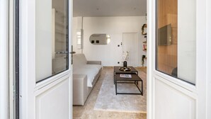 A modern living room with a sofa, a coffee table, and a TV. - Le Jaures RdC - 41 rue Jean Jaures - Vichy (Vichy)