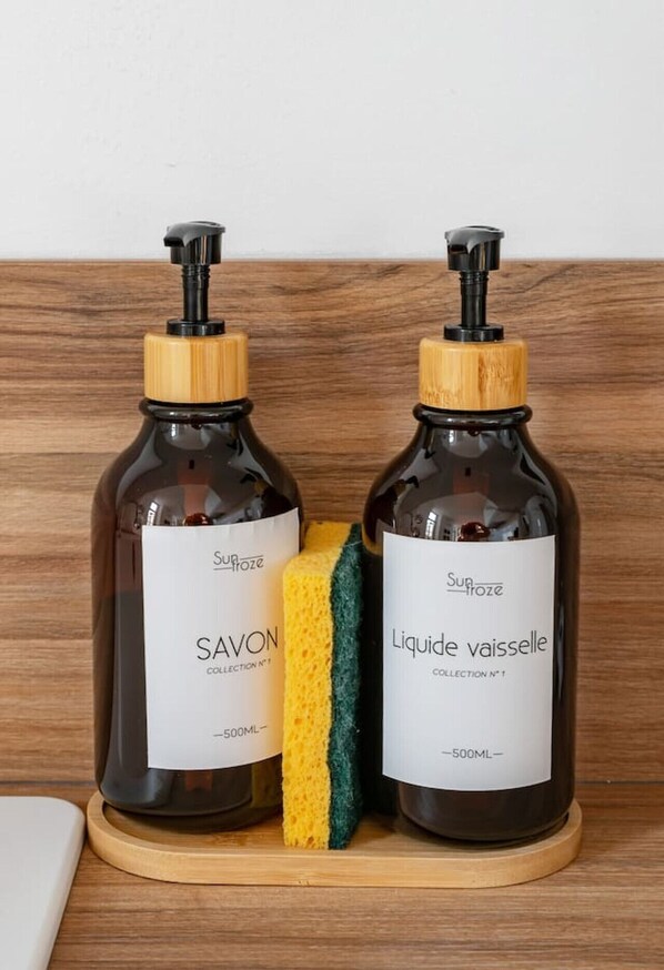 Two bottles of soap on a wooden surface.