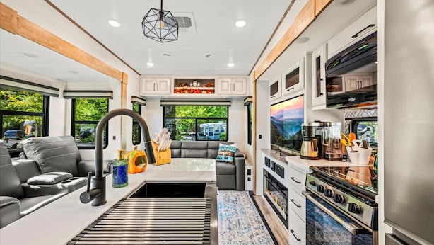 Interior moderno de una casa rodante con cocina, comedor y zona de estar.
