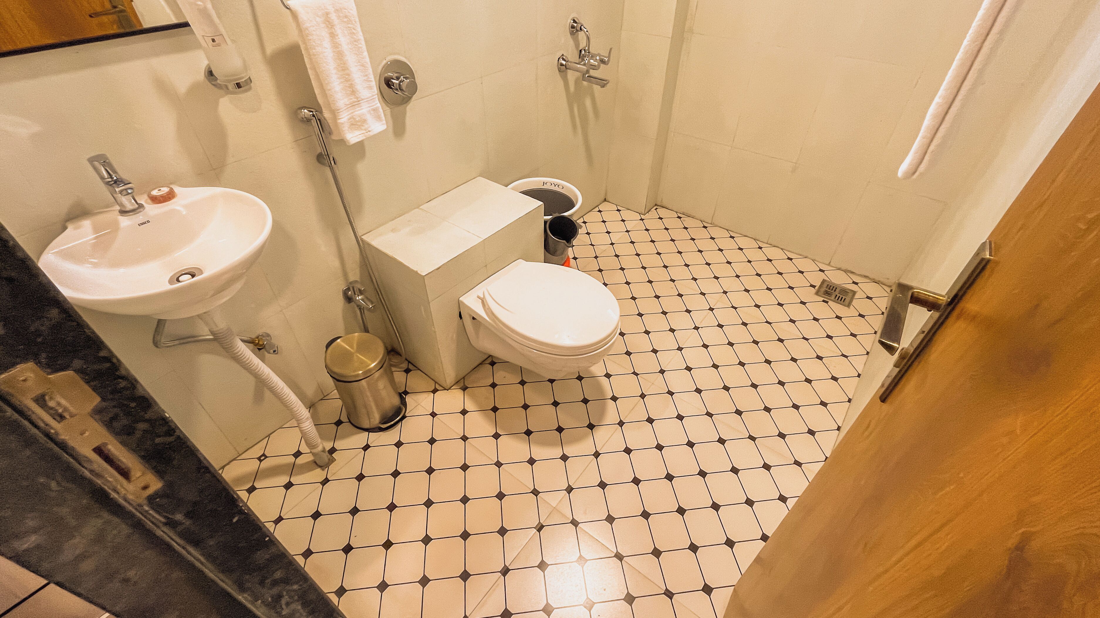 A small bathroom with a toilet, sink, and shower.