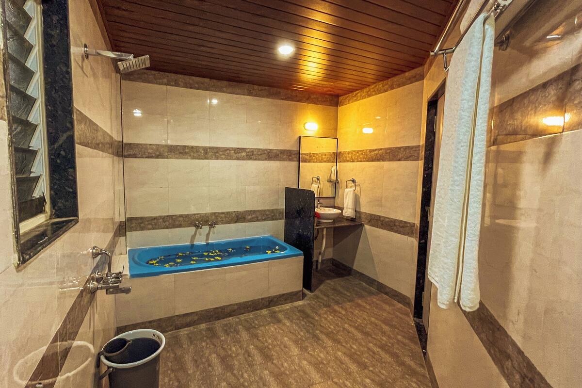 A bathroom with a bathtub, a shower, a sink, and a mirror.