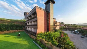 A modern hotel with a multi-story structure, a rooftop terrace, and a well-maintained lawn. - Regenta Bharti Amusement & Adventure Resort Pune, Urulikanchan (Daund)