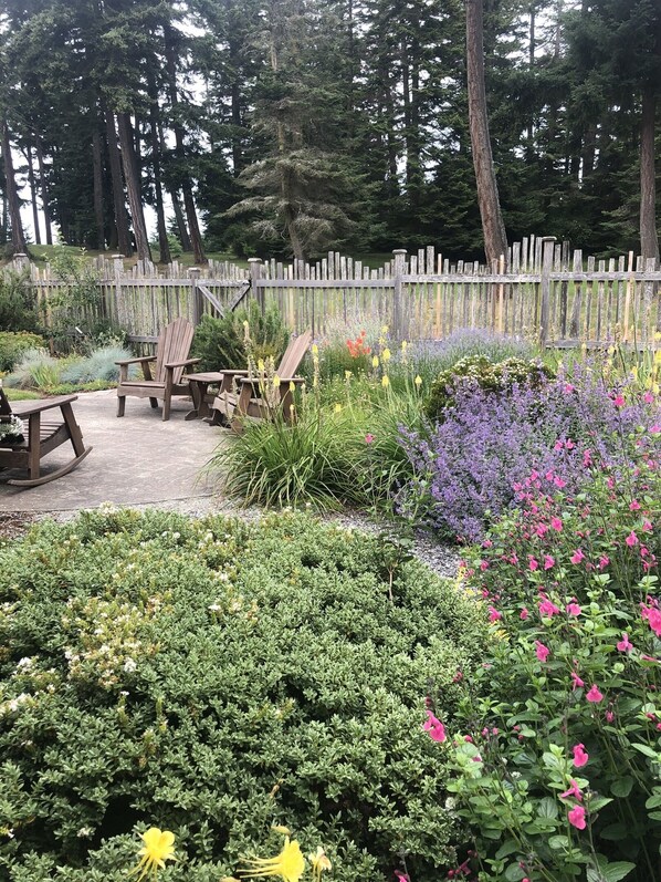 Un jardín con muebles y valla de madera.