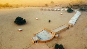 An aerial view of a desert resort with multiple tents and a central building with a pool. - Sonal Desert Camp Jaisalmer (Jaisalmer)