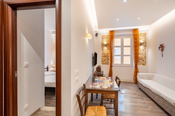 A dining area with a wooden table, chairs, and a sofa.