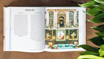 Ein Innenraum eines Hotels im klassischen europäischen Stil, mit einer zentralen Treppe, einer Sitzecke mit einer Couch und einem Empfangsbereich.