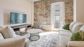 Ein modernes Wohnzimmer mit Kamin, Fernseher und Backsteinwand.